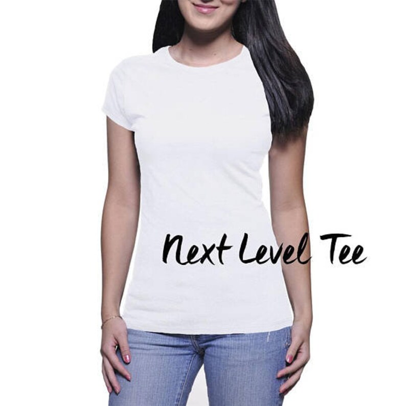 Puede incluir: Una camiseta blanca con el texto "Next Level Tee" impreso en la parte delantera.
