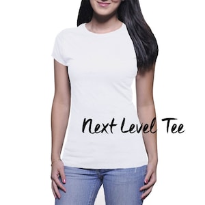Puede incluir: Una camiseta blanca con el texto "Next Level Tee" impreso en la parte delantera.