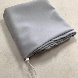 May include: A light gray, rectangular fabric pouch with a white drawstring closure.