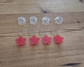 May include: Four clear glass bottles with cork stoppers and five pink flower-shaped sponges.
