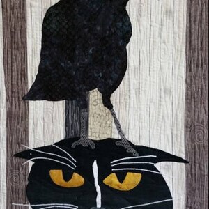 May include: A black cat with white markings and yellow eyes sits with a black raven perched on its head. The background is a woodgrain pattern.