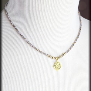 May include: A delicate necklace with a gold-colored pendant in a floral design. The necklace features small, light purple and gold beads. The text "MyCreativeSideJewels.etsy.com" is at the bottom of the image.