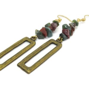 May include: Gold tone earrings with a rectangular dangle and a long chain of multi-coloured stone beads.