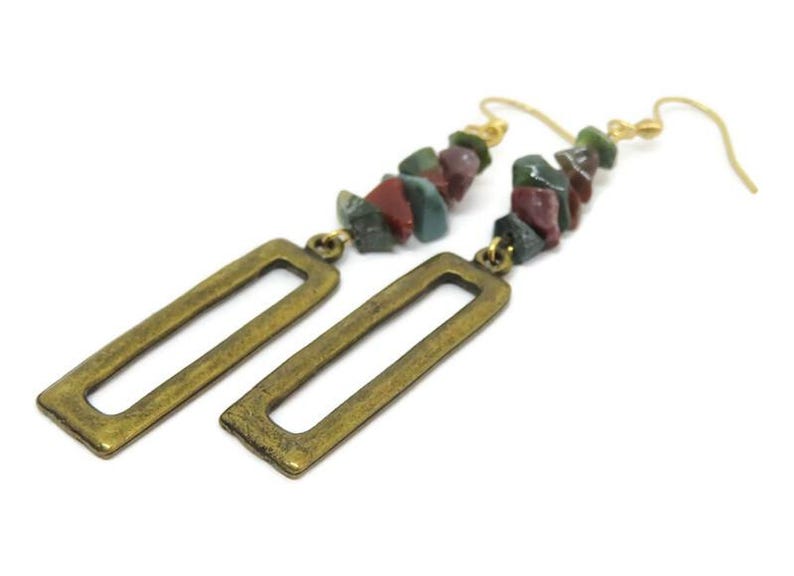 May include: Gold tone earrings with a rectangular dangle and a long chain of multi-coloured stone beads.