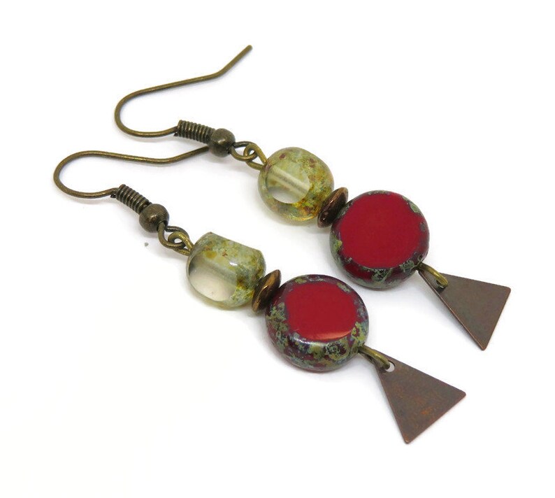 Op de afbeelding: Een paar oorhangers met een rood, groen en gouden kleurenschema. De oorhangers hebben een rode en groene gespikkelde ronde kraal, een heldere glazen kraal met gouden vlekken en een kleine driehoekige hanger.