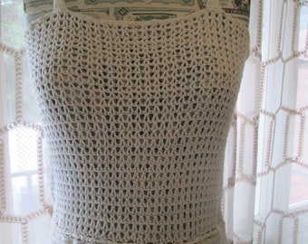 May include: A white crochet dress with a tie at the waist. The dress is made of a delicate, open-weave fabric.