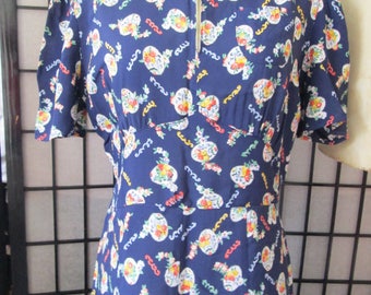 May include: A navy blue dress with a white zip and a floral print of red, yellow, and blue flowers. The dress has short sleeves and a collared neckline.