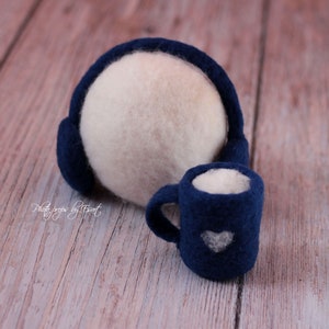 May include: A white felt ball with blue felt earmuffs and a blue felt mug with a white heart design.