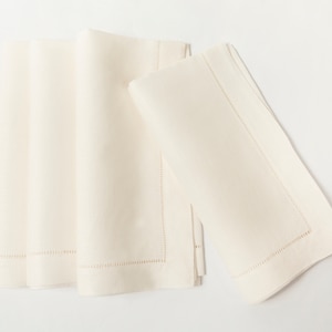 Puede incluir: Servilletas de lino color crema, dobladas y apiladas. Las servilletas tienen un borde cosido. El color neutro y el dise&ntilde;o cl&aacute;sico las hacen adecuadas para diversas mesas, a&ntilde;adiendo un toque de elegancia.