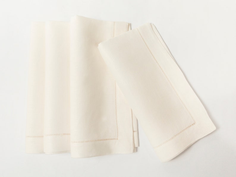 Puede incluir: Servilletas de lino color crema, dobladas y apiladas. Las servilletas tienen un borde cosido. El color neutro y el dise&ntilde;o cl&aacute;sico las hacen adecuadas para diversas mesas, a&ntilde;adiendo un toque de elegancia.