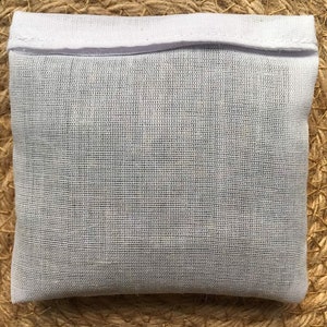 May include: White cotton drawstring bag with a white fabric top. The bag is made of a fine mesh material.