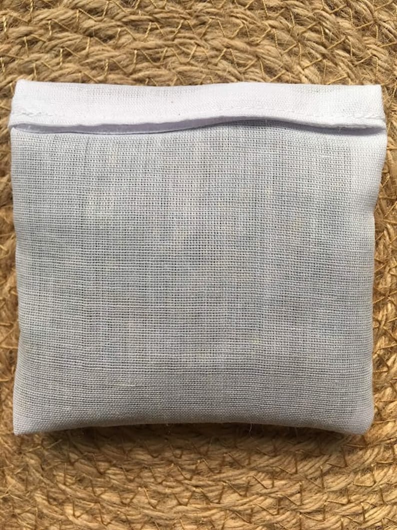 May include: White cotton drawstring bag with a white fabric top. The bag is made of a fine mesh material.