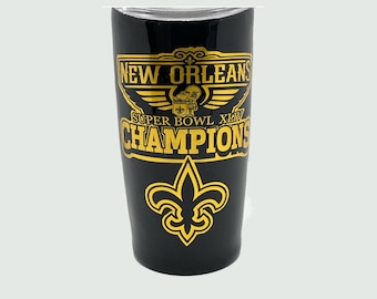 May include: Black and gold stainless steel tumbler with the words "New Orleans Super Bowl XLIV Champions" and a fleur-de-lis design.