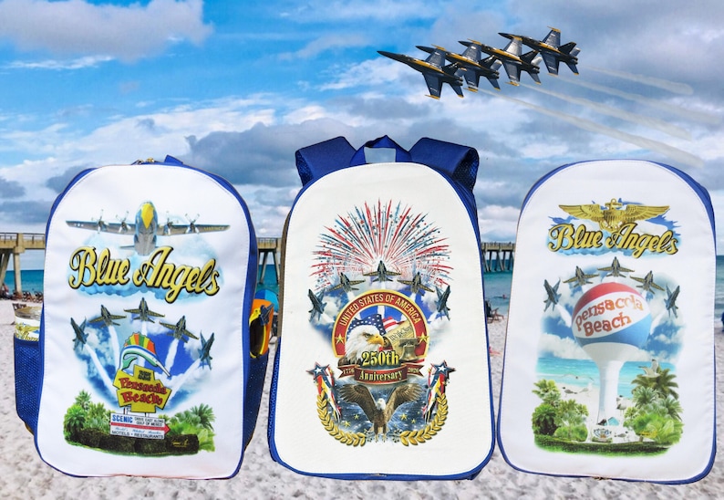 Pu&ograve; includere: Tre zaini bianchi e blu con grafiche Blue Angels. Uno presenta un aereo e le parole "Pensacola Beach". Un altro mostra fuochi d'artificio e un'aquila con "250th Anniversary". Il terzo mostra un serbatoio d'acqua.