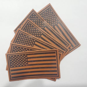 May include: A set of six brown leather American flag patches. Each patch features a black outline and a brown leather background.