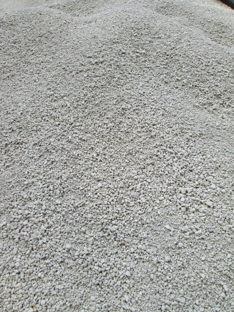 May include: A close-up view of a pile of small, white gravel. The gravel is smooth and uniform in size.