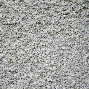 May include: A close-up of a pile of small, white, and gray gravel. The gravel is a mix of different sizes and shapes.