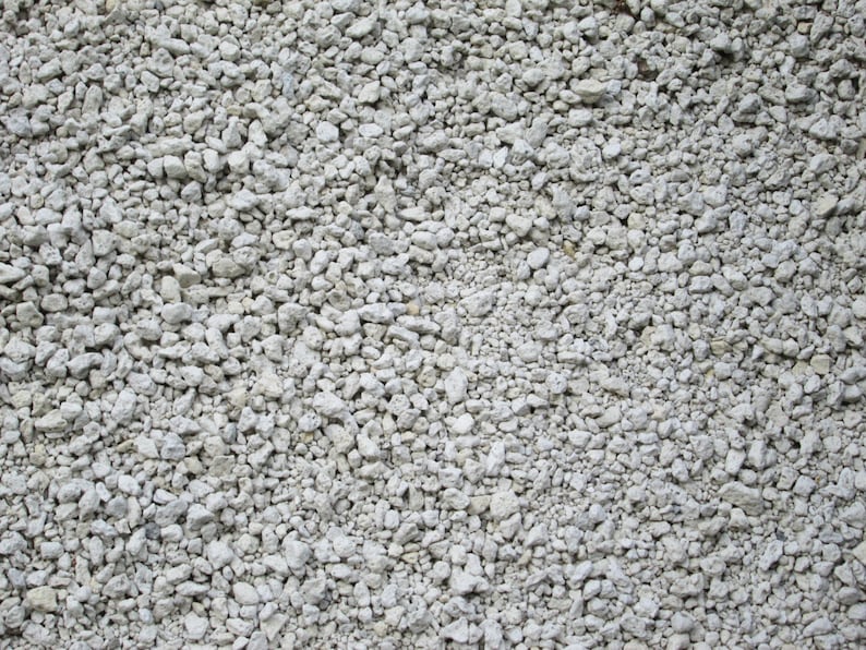 May include: A close-up of a pile of small, white, and gray gravel. The gravel is a mix of different sizes and shapes.
