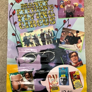May include: A promotional poster for Monty Python's Flying Circus, with the show's title in a decorative font. The poster incorporates images from the show, VHS tapes, and the text "The First 3 Volumes Now On Videocassette And Laser VideoDisc."