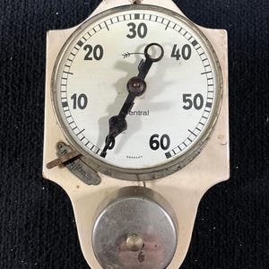 Può includere: Orologio da parete vintage color crema con quadrante rotondo e campanello. Il quadrante dell'orologio ha numeri e lancette nere, con la parola "Central" stampata sul quadrante. L'orologio è contrassegnato "Germany".