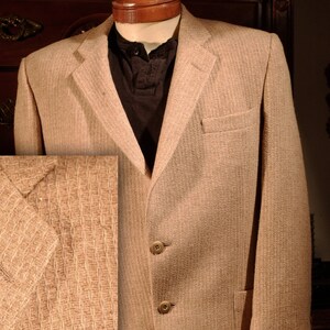Peut inclure: Un blazer beige avec un tissu tissé texturé. Le blazer a une fermeture à simple boutonnage avec deux boutons et une poche sur le côté gauche.