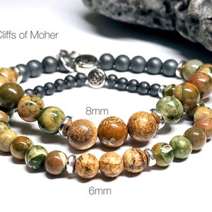 May include: Two bracelets made with green, brown, and white patterned stones. The smaller bracelet has 6 mm beads and the larger bracelet has 8 mm beads. The text "Cliffs of Moher" is visible in the image.