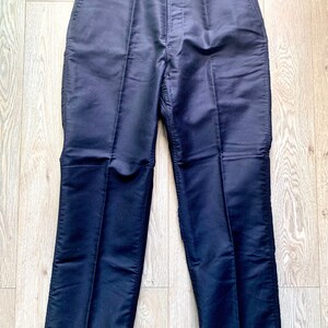 May include: A pair of dark blue pants with a straight leg and a button fly.
