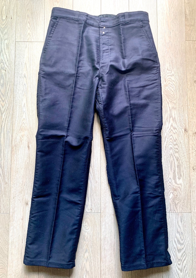 May include: A pair of dark blue pants with a straight leg and a button fly.