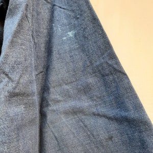 Puede incluir: Primer plano de una tela vaquera azul oscuro con una mancha azul claro.