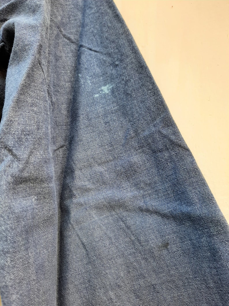 Puede incluir: Primer plano de una tela vaquera azul oscuro con una mancha azul claro.