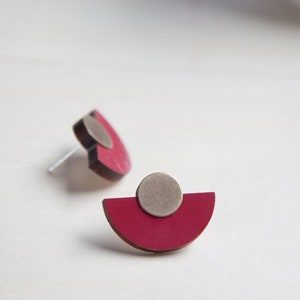 Peut inclure: Une paire de boucles d'oreilles en demi-cercle rouge et gris avec une tige argentée.