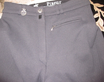 May include: Black riding breeches with a zippered pocket on the right leg and the word "Pikeur" on the waistband.