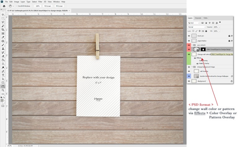 May include: A digital mockup template in PSD format featuring a vertical 5x7 inch white card with diagonal gray stripes, held by a wooden clothespin on a string against a light brown horizontal wood plank background, with a layer panel visible.