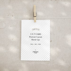 May include: A white rectangular 5 x 7 card with a diagonal gray stripe pattern, held by a wooden clothespin on a string. The text reads: simple & easy, 5 X 7 CARD, Portrait Layout, Mock Ups, PNG | JPG | PSD, by J Square Presents.