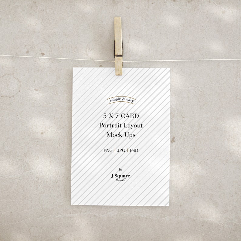 May include: A white rectangular 5 x 7 card with a diagonal gray stripe pattern, held by a wooden clothespin on a string. The text reads: simple & easy, 5 X 7 CARD, Portrait Layout, Mock Ups, PNG | JPG | PSD, by J Square Presents.