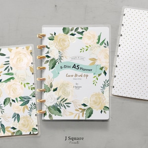 May include: A white A5 planner cover mockup with a floral design featuring white roses and gold accents. The text "8-Disc A5 Planner Cover Mock Up PNG PSD by J Square" is printed on the cover.