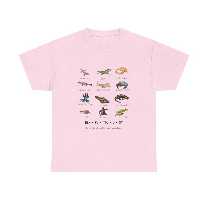 May include: Light pink t-shirt featuring a colorful illustration of various reptiles and amphibians, including geckos, lizards, and frogs. The word "HERPETOLOGY" is printed below the illustrations, along with the phrase "The study of reptiles and amphibians."