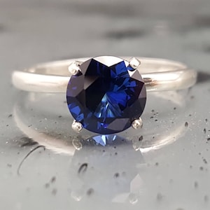 Anillo de compromiso solitario de plata con zafiro azul