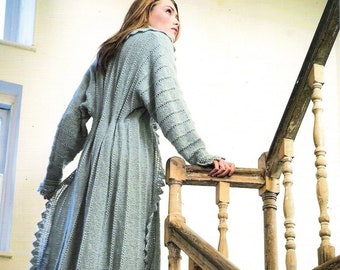 May include: A woman wearing a long, light blue crocheted dress with a lacy trim stands on a wooden staircase. The staircase has a wooden handrail and spindles.