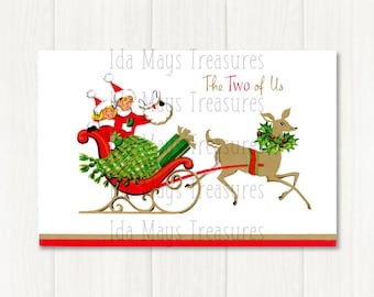 May include: A vintage-style Christmas greeting card illustration featuring two figures in red Santa hats riding in a red sleigh pulled by a brown reindeer. The reindeer wears a green holly wreath. The text reads The Two of Us in script.