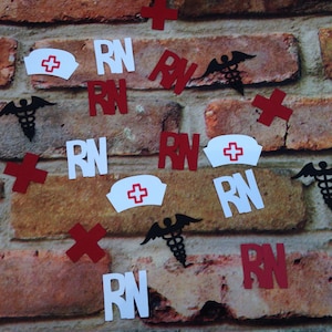 May include: A brick wall background with red, white, and black paper cutouts of the letters RN, a red cross, and a caduceus symbol.