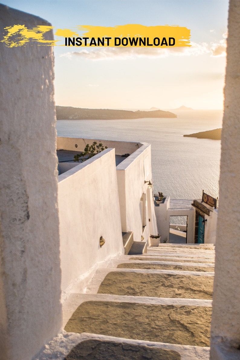 May include: Whitewashed steps leading up to a building with a view of the ocean and a distant island. The steps are made of stone and have a rough texture. The building is white and has a simple design. The ocean is blue and calm. The sky is a light blue and there are some clouds in the distance.