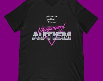 Peut inclure: T-shirt noir avec l'inscription "please be patient, I have Weaponized AUTISM" dans une police rétro. Le design comprend un triangle rose et un effet de dégradé sur le texte, créant un look audacieux.