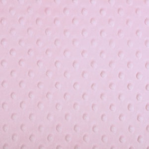May include: A close-up of a soft, pink fabric with a textured, dotted pattern. The fabric has a subtle sheen and a smooth, velvety feel.
