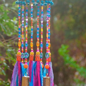Móvil bohemio con cuentas: campanas de latón y borlas de tela.