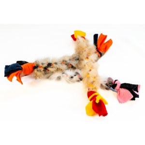 May include: A multi-colored cat toy with a long, furry tail and multiple knotted fabric ends in shades of orange, yellow, red, blue, and pink.