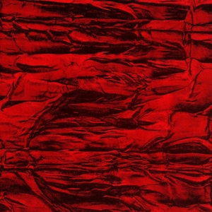 May include: A close-up of a crumpled, ruby red fabric with a textured surface.