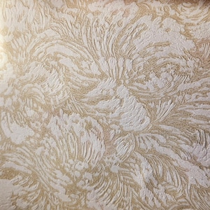 May include: Close-up of a textured wallpaper with a swirling pattern in shades of beige and white.