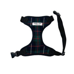 May include: Dog harness in a green and navy tartan pattern, with red accents. It features black straps and buckles. The text "Barkley & Fitch Canine Outfitters" is visible on the front.
