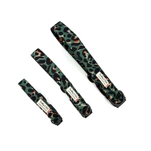 May include: Three dog leads with a green and brown leopard print design. Each lead has a black metal ring and a label that reads "Barkley & Fitch Canine Outfitters" with a Union Jack flag.